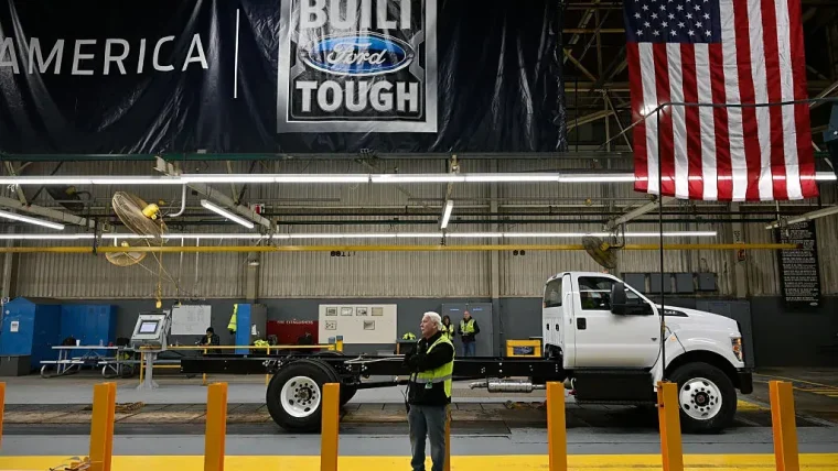 Veteran Ford engineers inspecting car parts on an assembly line, demonstrating quality control