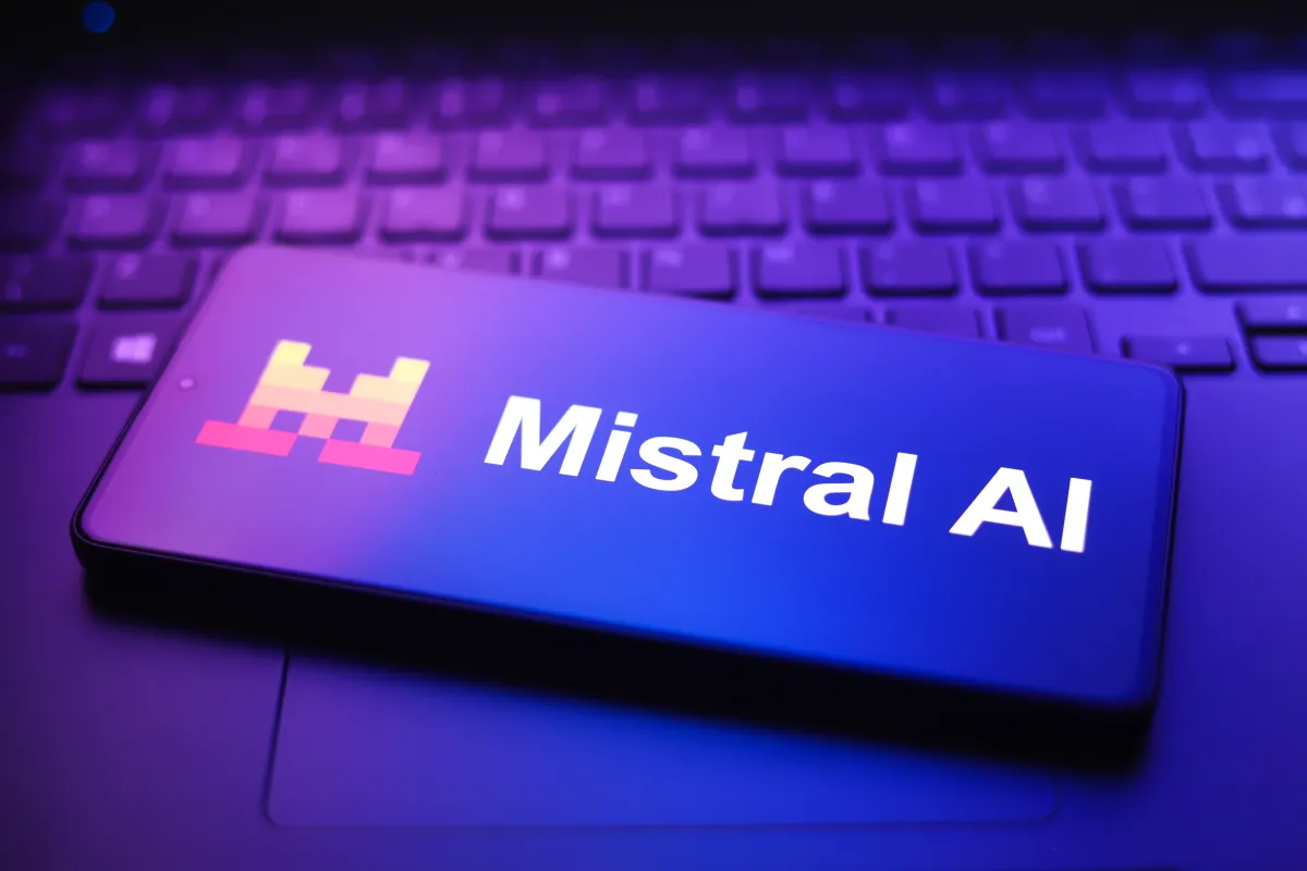 The Mistral AI company logo displayed prominently, with a blurred background of a modern office space, symbolizing innovation and growth in artificial intelligence.