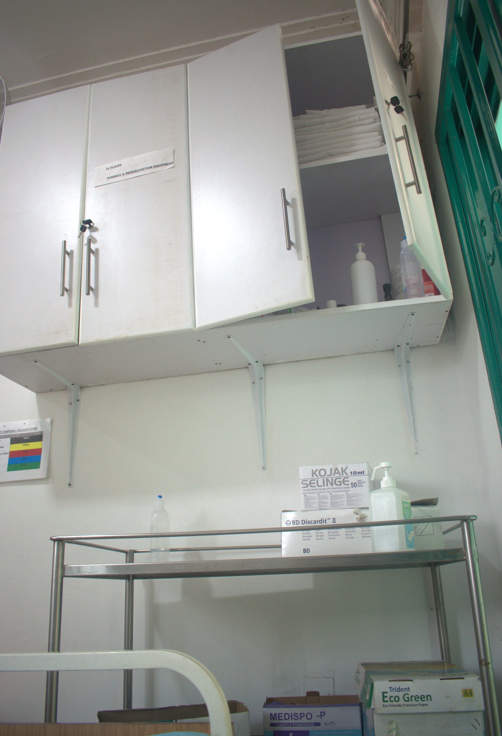 A healthcare professional interacting with an AI interface on a tablet in an Indian hospital setting, with medical equipment in the background.