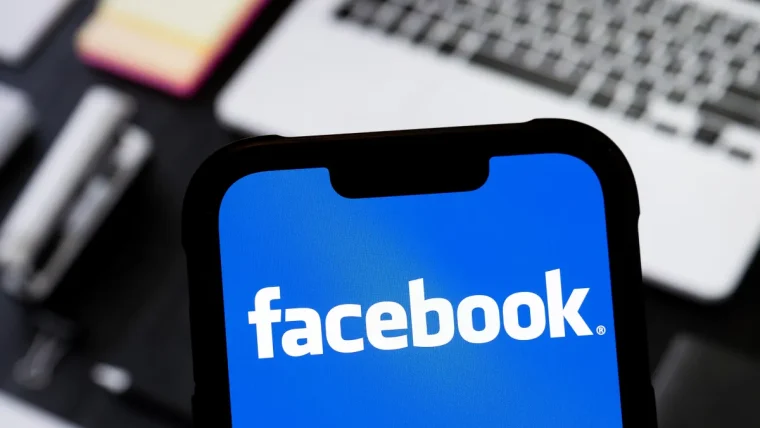 A creator looking at a smartphone displaying Facebook's new AI companion app interface, with graphs and AI-generated content suggestions