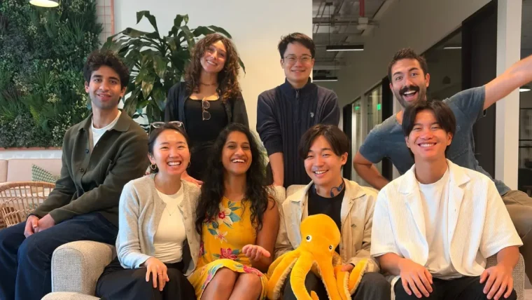 JustAI team members celebrating a successful funding round, with graphics representing AI and marketing technology.