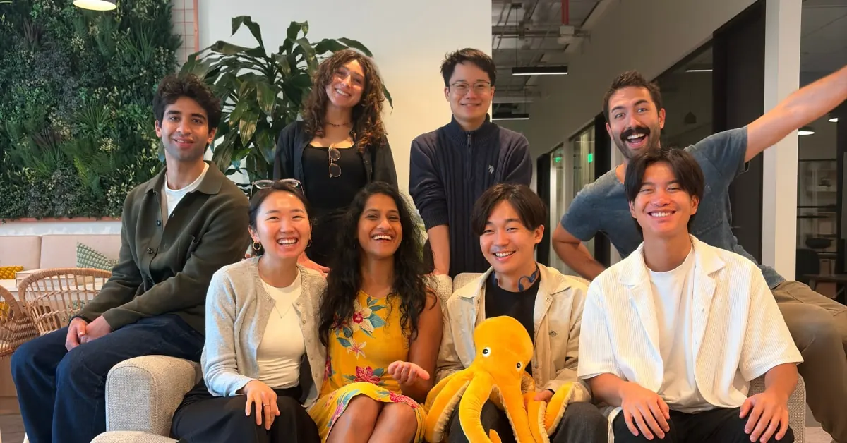 JustAI team members celebrating a successful funding round, with graphics representing AI and marketing technology.
