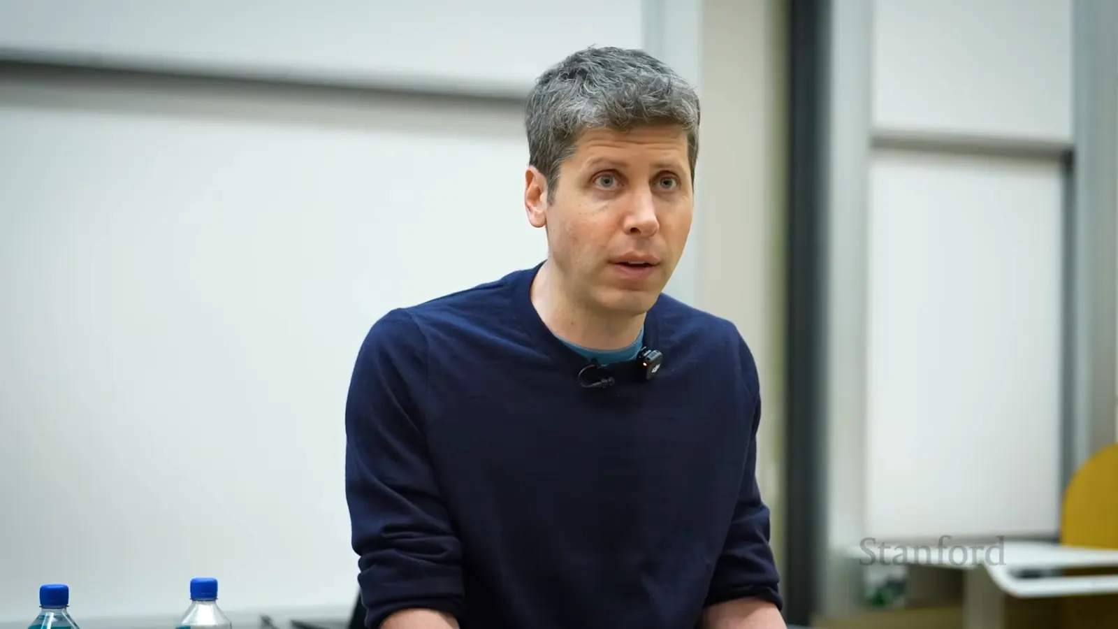 Sam Altman, CEO of OpenAI, speaking at a podium about the future of artificial intelligence