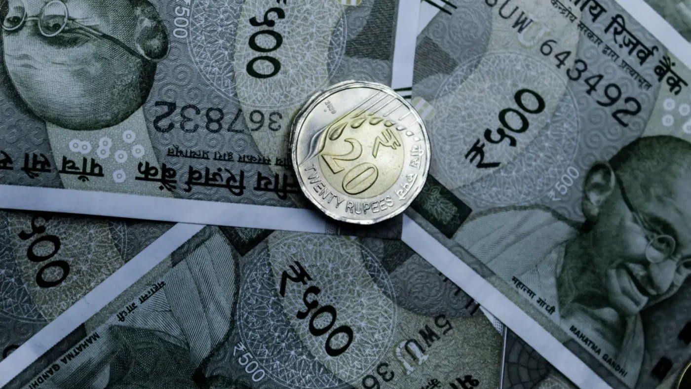 Detailed close-up of Indian 500-rupee notes and a 20-rupee coin, highlighting currency details.