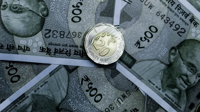 Detailed close-up of Indian 500-rupee notes and a 20-rupee coin, highlighting currency details.