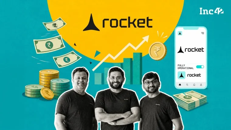 A graphic representation of an AI coding platform interface, with lines of code forming a rocket icon, suggesting rapid development, set against a subtle Indian tech landscape