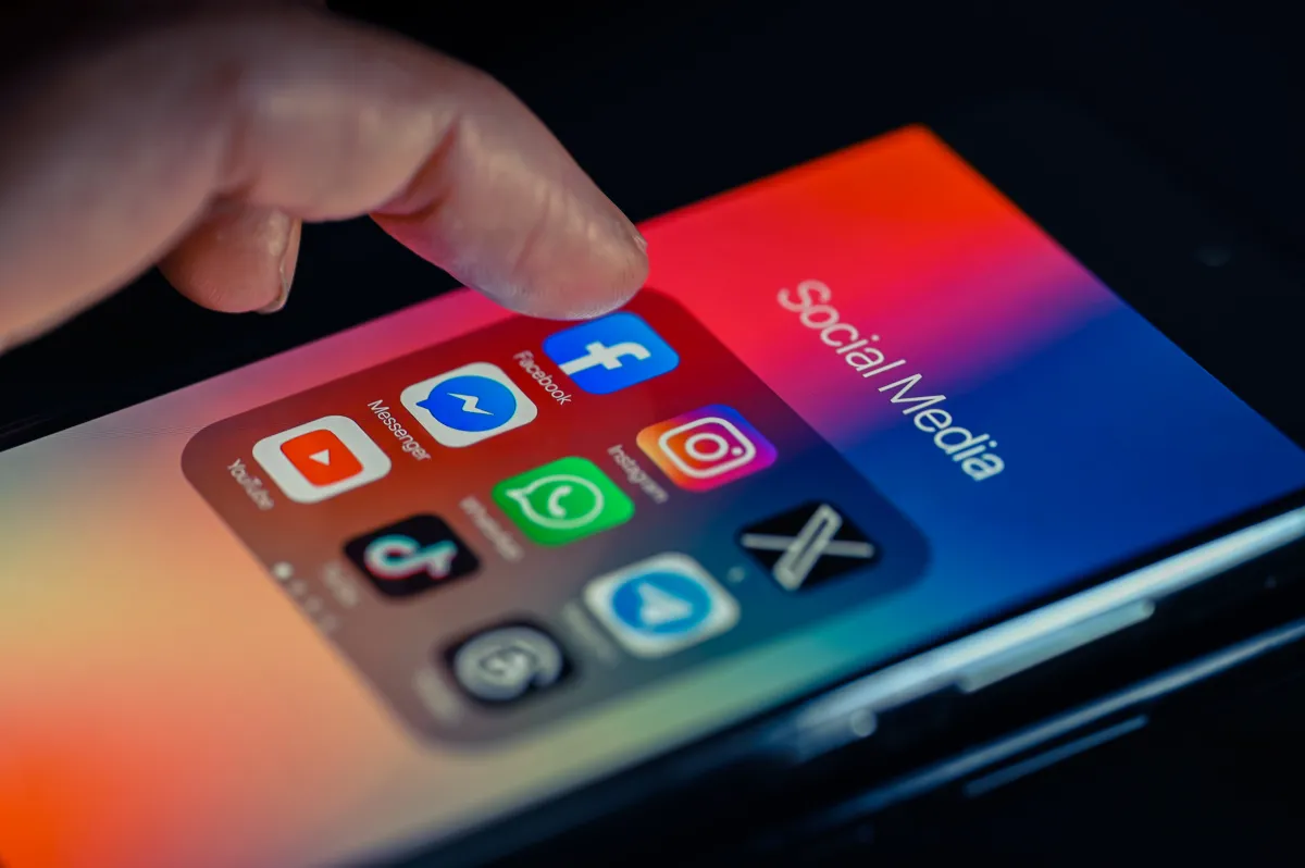 A user's hand holding a smartphone, with a social media feed displaying various content. Overlayed graphical elements suggest AI algorithms and personalization settings