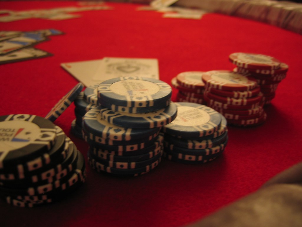 A magnifying glass over fine print terms and conditions, with blurred casino chips and cards in the background, symbolising the importance of understanding bonus rules.