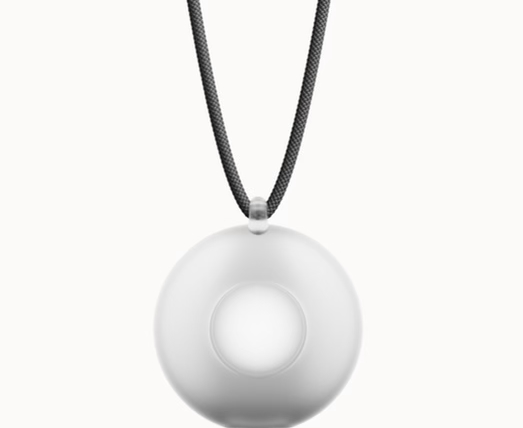 A woman wearing the Friend AI wearable necklace, holding a conversation with the device