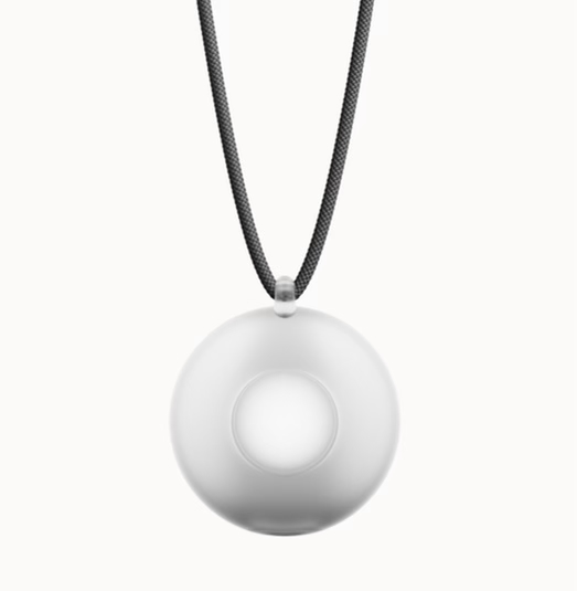 A woman wearing the Friend AI wearable necklace, holding a conversation with the device