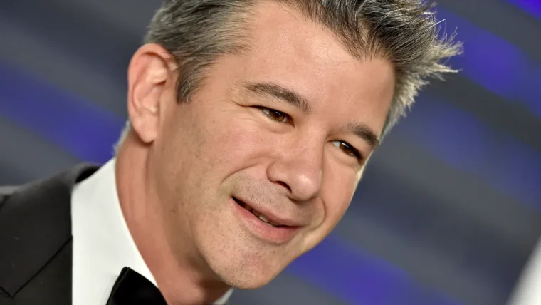 Travis Kalanick, former Uber CEO, discussing the future of industrial robotics and AI with a backdrop of automated factory machinery.