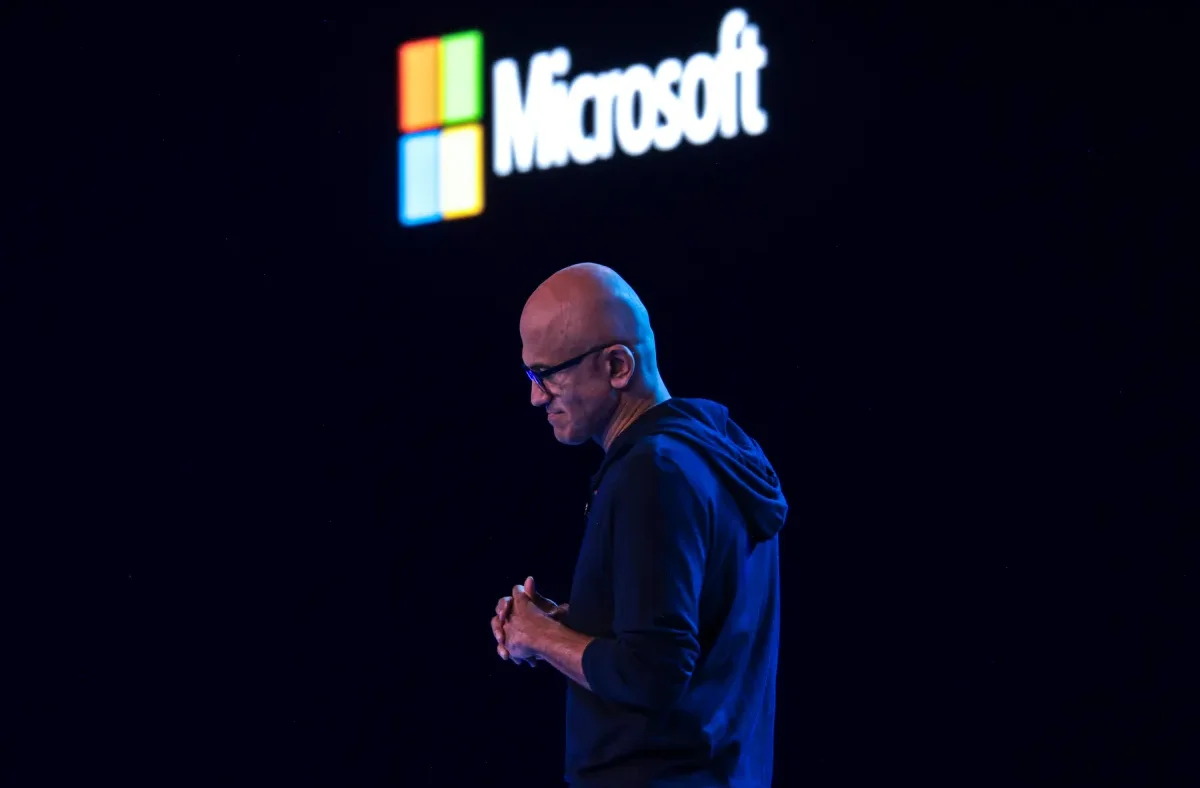Microsoft logo displayed alongside a graphic representing AI models and cost-saving measures, indicating a strategic shift.
