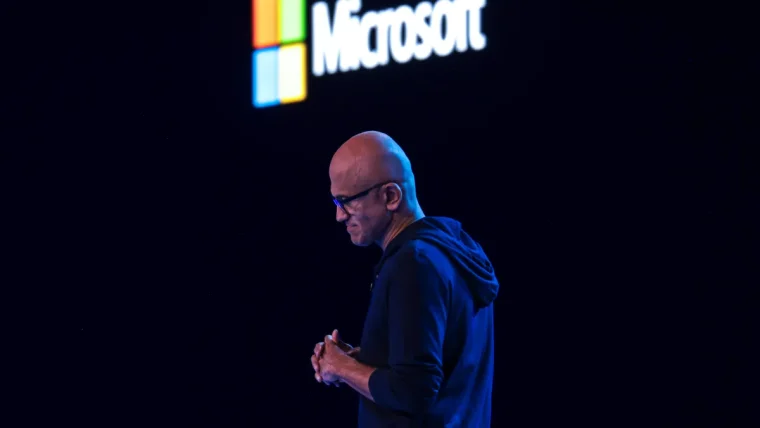 Microsoft logo displayed alongside a graphic representing AI models and cost-saving measures, indicating a strategic shift.