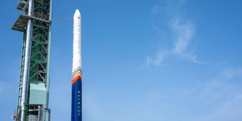 The Skyroot Vikram-1 rocket lifting off from a launchpad, with smoke and fire trailing, against a clear sky.
