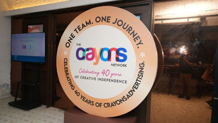 Indian advertising professionals collaborating, with subtle AI visual elements, representing Crayons Advertising's 40-year milestone and AI focus.